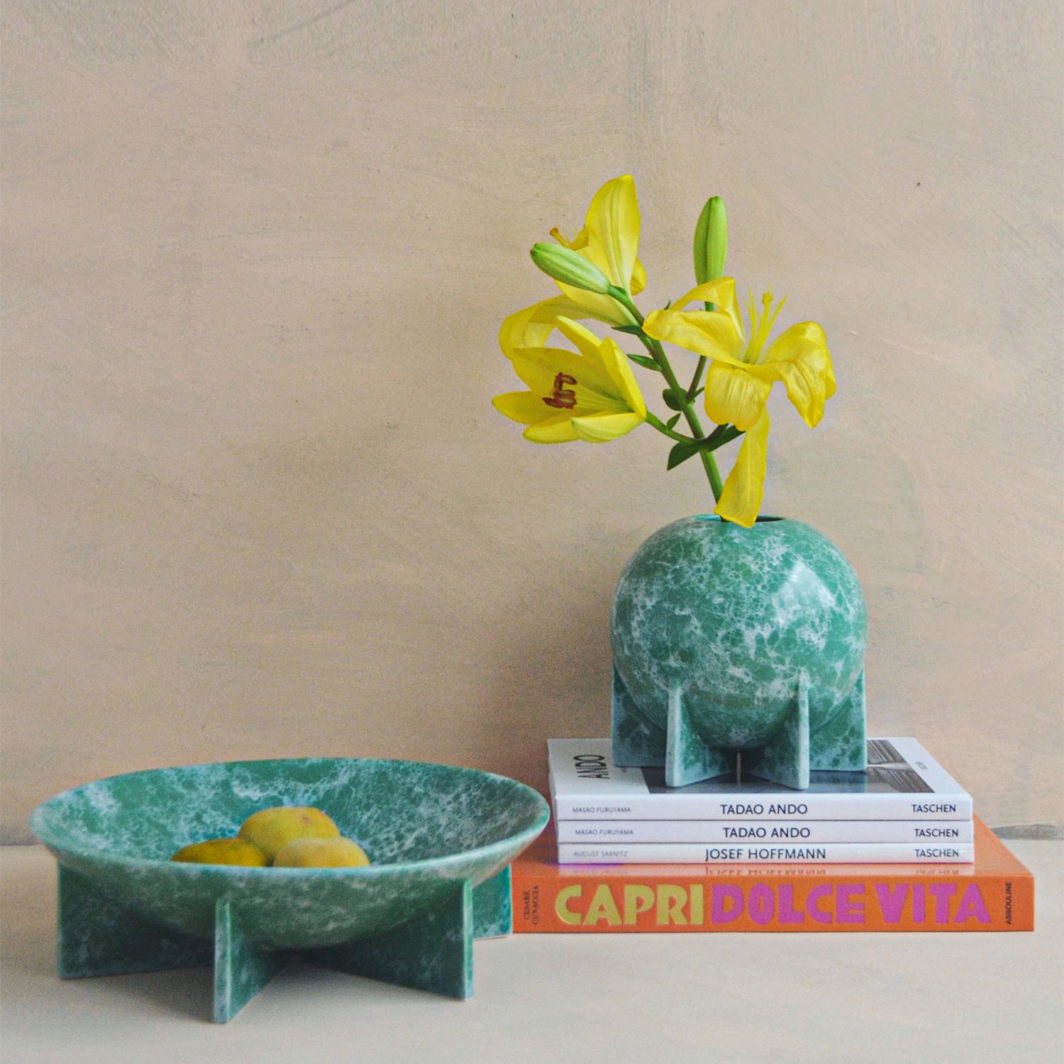 Plato y florero verde con libros decorativos