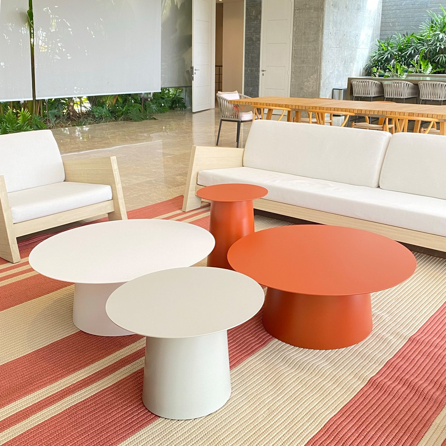 Muebles de terraza con mesas naranja y blanco