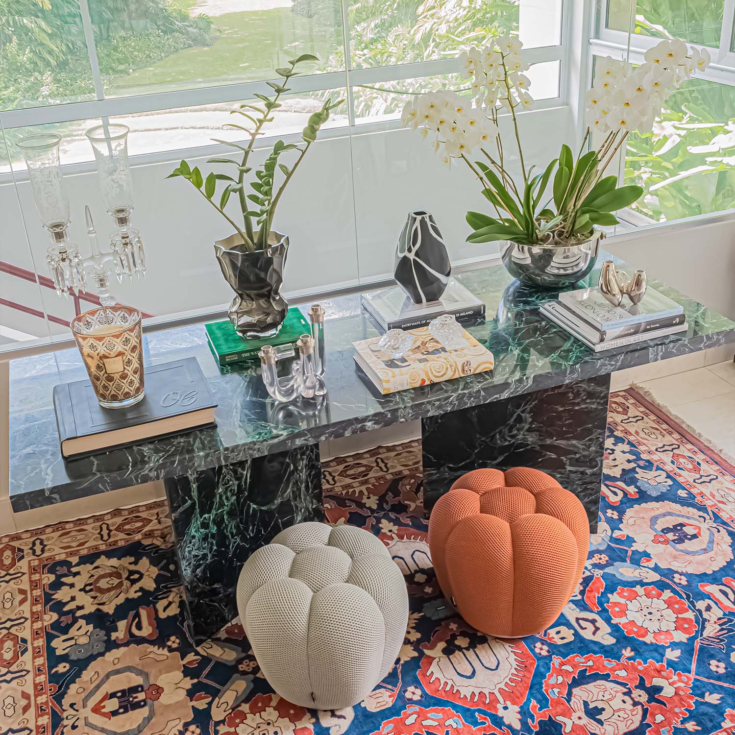 A stylish green marble console paired with a set of two cozy poufs.