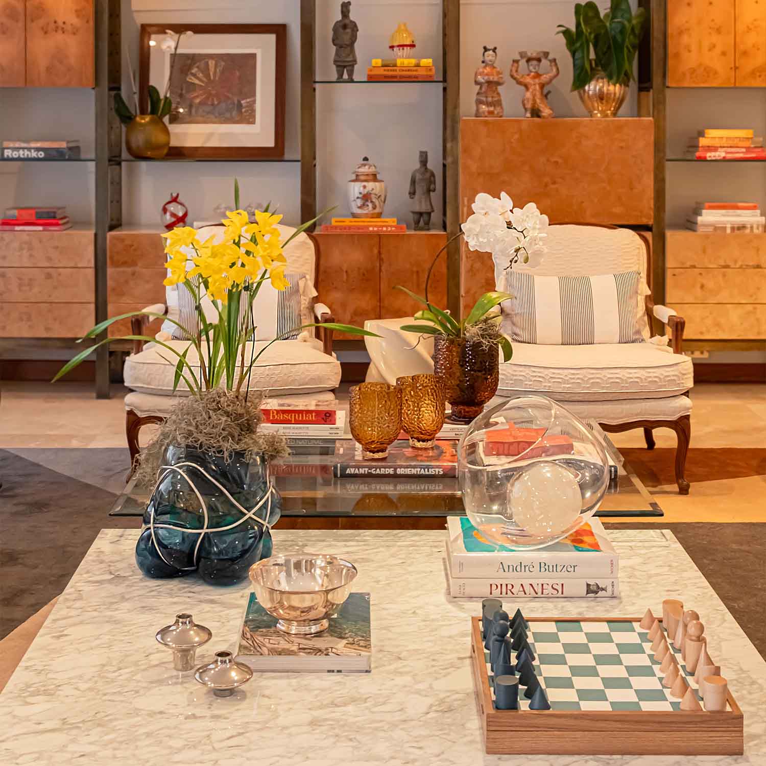 Living room scene with two armchairs, a coffee table, and a bookcase