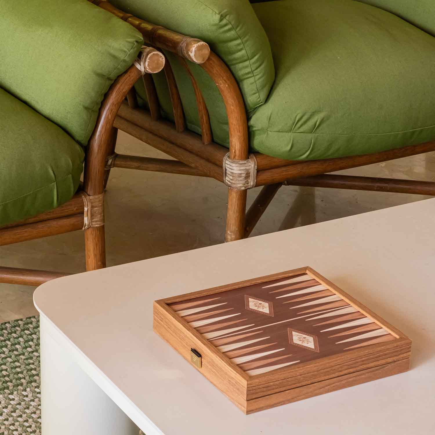 Juego de damas sobre mesa y de fondo, detalle de sillones verdes