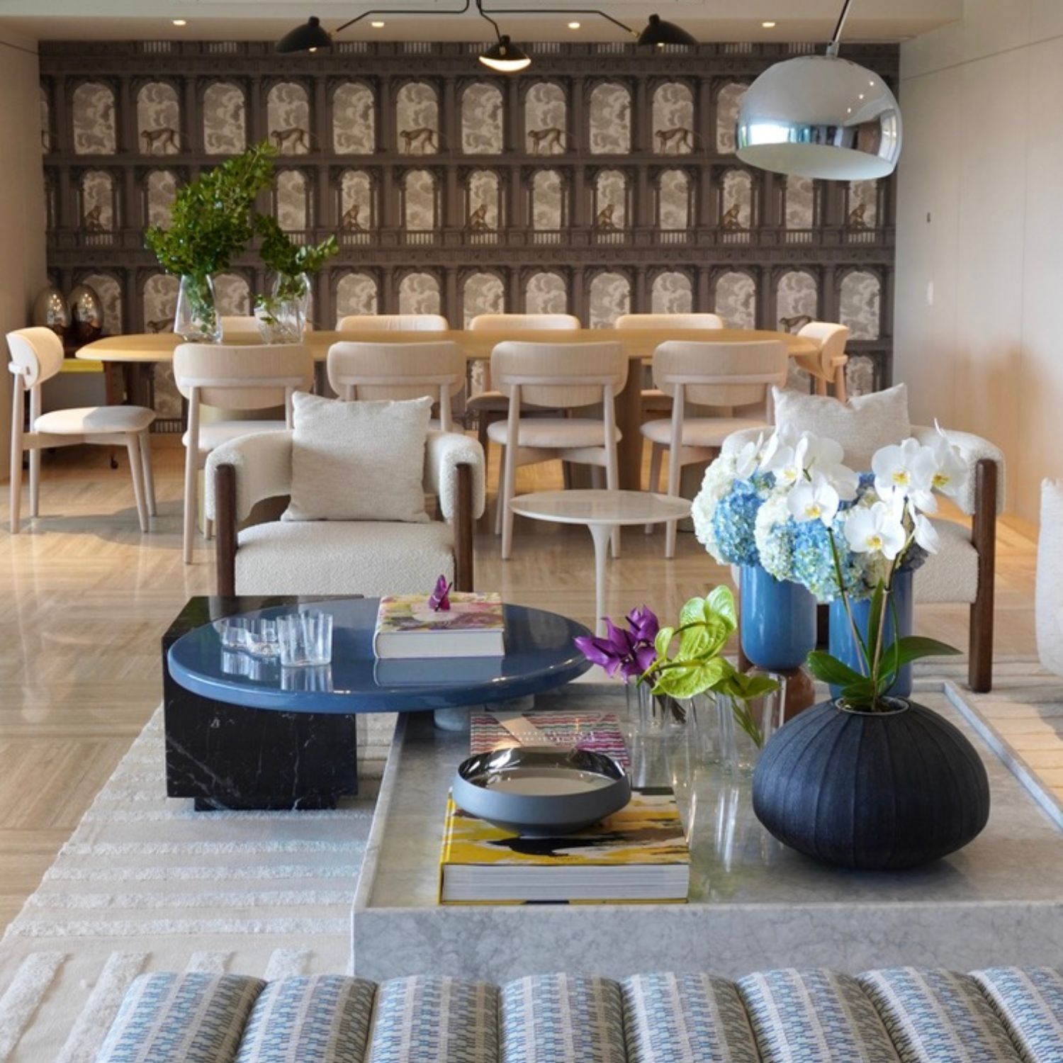 Modern living room with marble coffee table and dining area in the background with artistic wall, Residential Project 22 by Volante Studio.