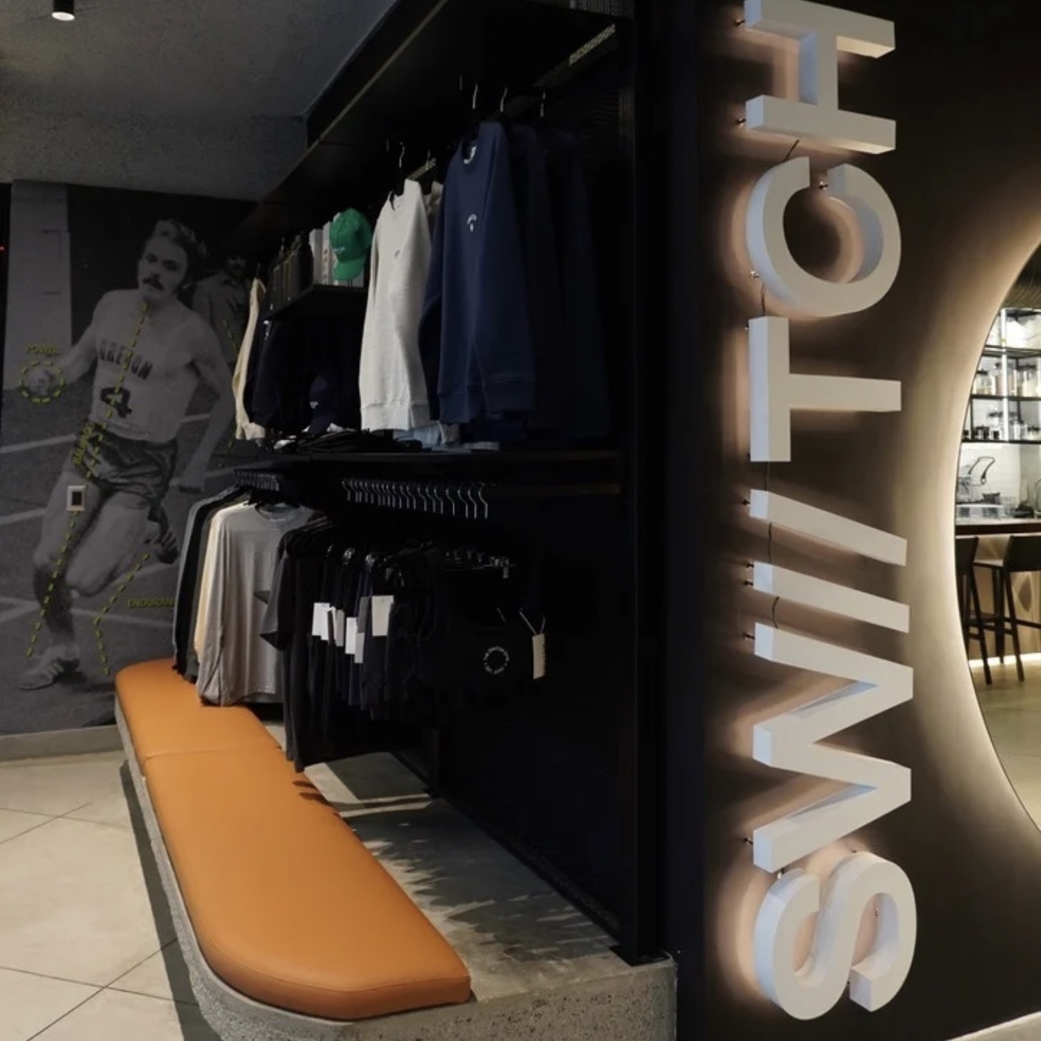 Área de tienda en el gimnasio SWIITCH, Caracas, con ropa deportiva, gorras y accesorios diseñados con identidad de marca.