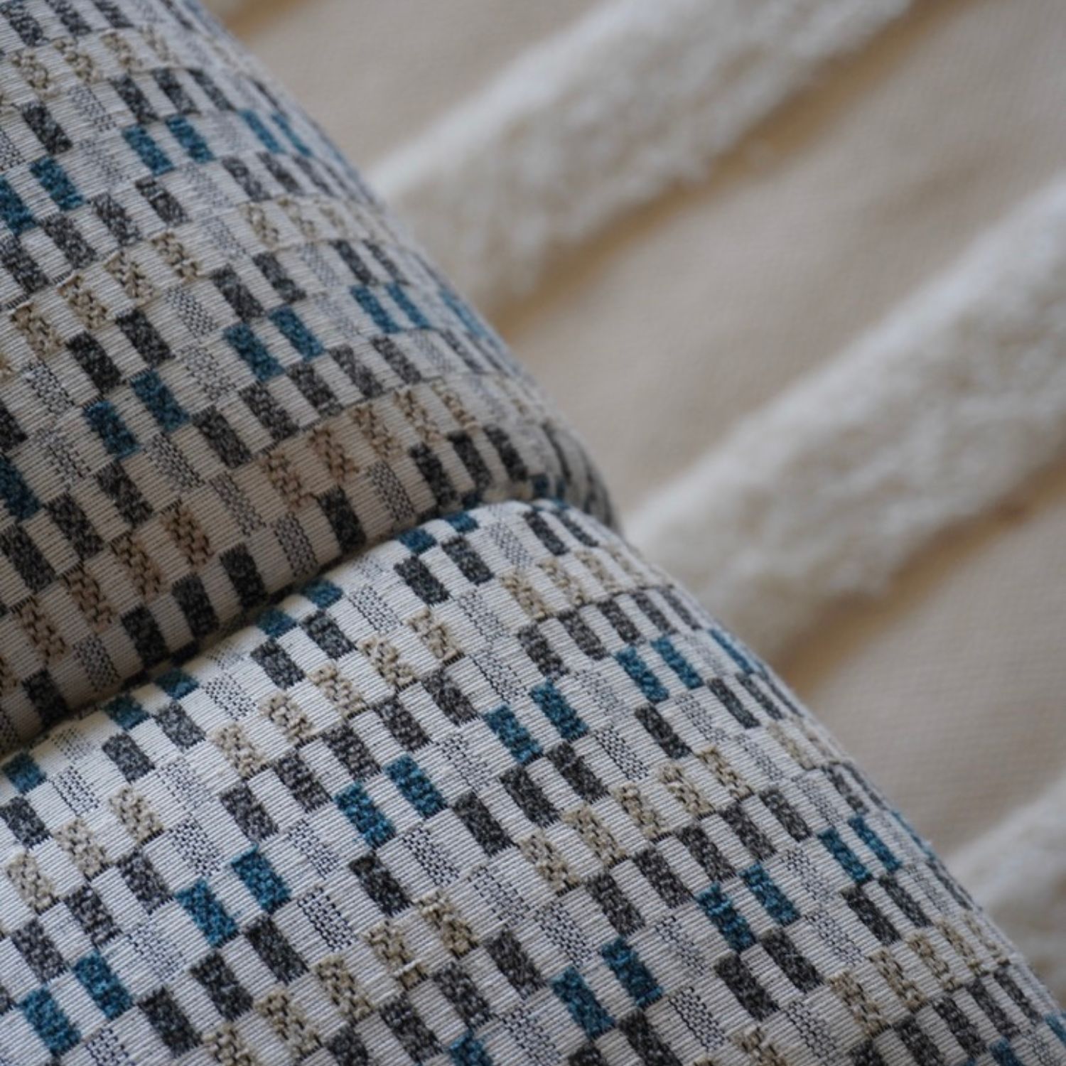 Primer plano de tapizado en tonos azules y beige sobre alfombra texturizada, detalle del Proyecto Residencial 22.