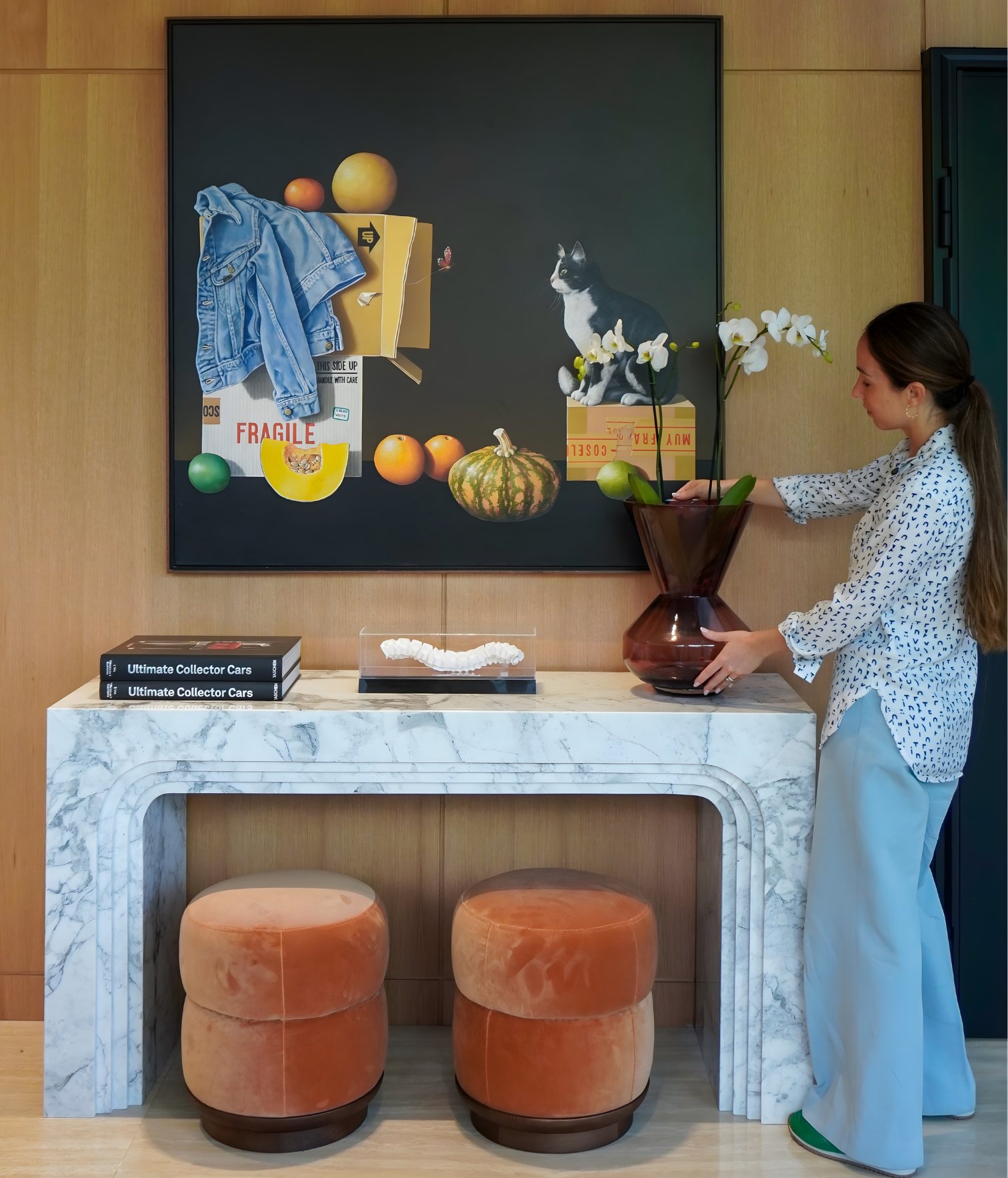 Interior designer Ana Volante styling the marble console with terracota velvet poufs of the entry room area